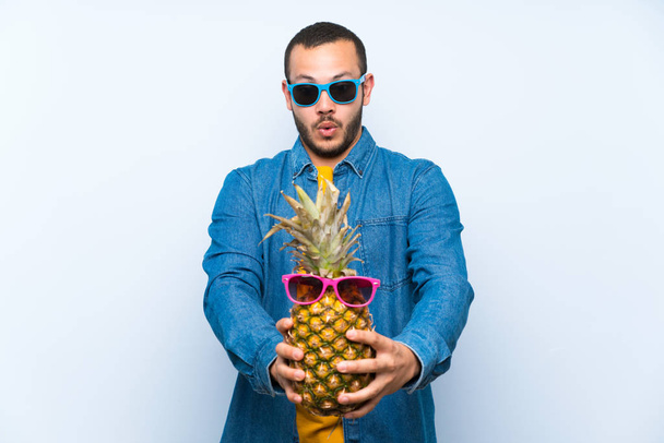 Colombian man holding a pineapple with sunglasses - Foto, immagini