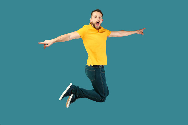 Screaming jumping man on color background - Photo, Image