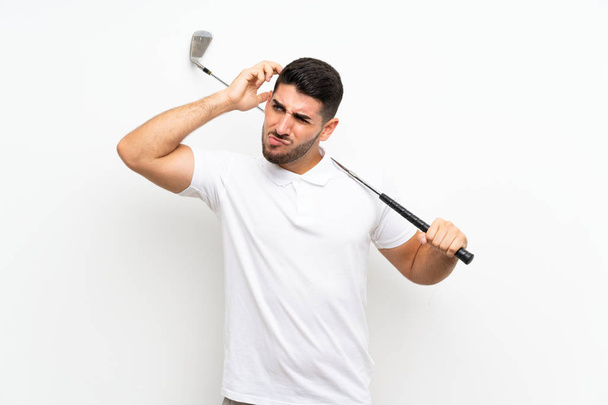 Handsome young golfer player man over isolated white background having doubts and with confuse face expression - Photo, Image