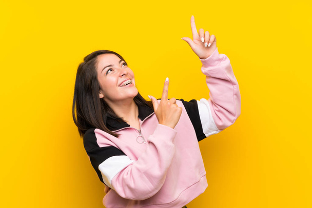 Jeune femme mexicaine sur fond jaune isolé pointant avec l'index une excellente idée
 - Photo, image