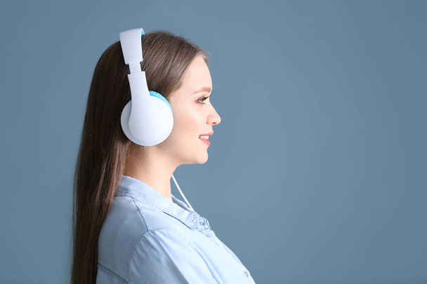 Kaunis nuori nainen kuuntelee musiikkia taustaa vasten - Valokuva, kuva
