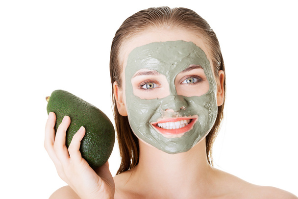 Beautiful woman with green avocado clay facial mask - Foto, Bild