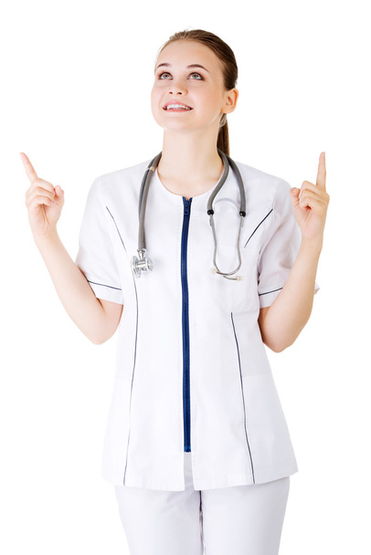 Woman doctor or nurse pointing on copy space. - 写真・画像