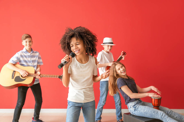 Teini-ikäiset muusikot pelaavat väriseinää vastaan
 - Valokuva, kuva