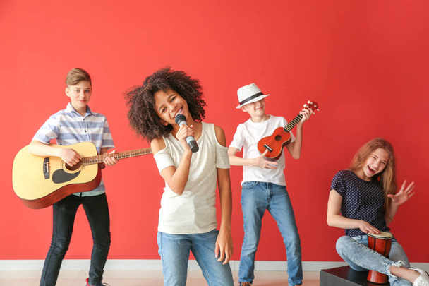 Músicos adolescentes tocando contra a parede de cores
 - Foto, Imagem
