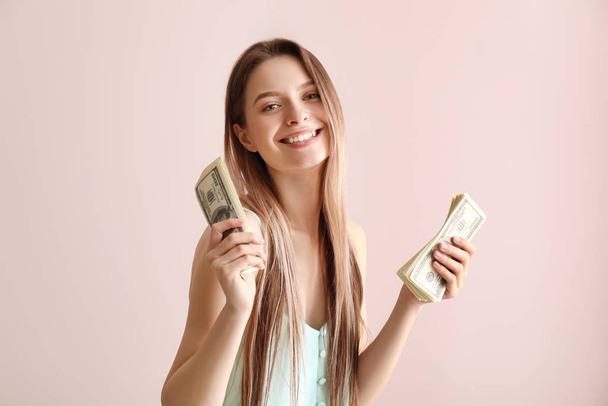 Щаслива молода жінка з грошима на кольоровому фоні
 - Фото, зображення