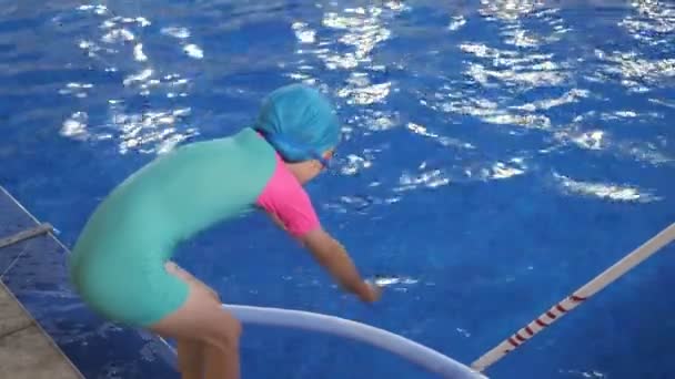 Gyermek lány megtanulja, hogy merülés a medencében álló helyzetben a kinyújtott kezet. - Felvétel, videó