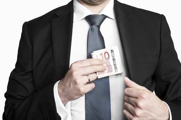 Бізнесмен в костюмі і краватка ховає гроші в кишені
 - Фото, зображення