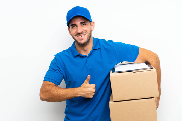 Delivery man over isolated white background giving a thumbs up gesture - Photo, Image