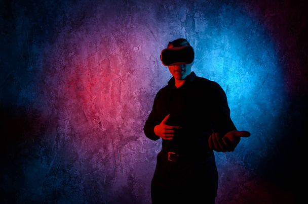 Young man playing a virtual reality video game. Vr game with shotgun - Fotó, kép