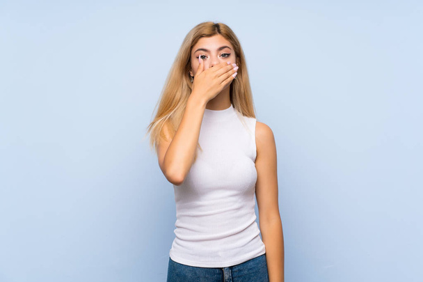 Teenager girl over isolated blue background surprised and showing ok sign - Foto, Imagem