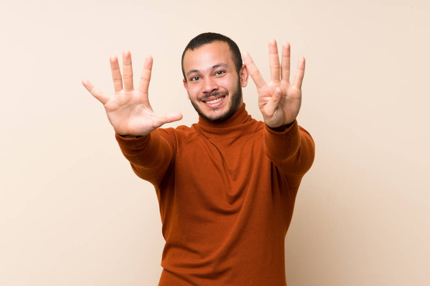 Hombre colombiano con jersey de cuello alto contando nueve con los dedos
 - Foto, Imagen