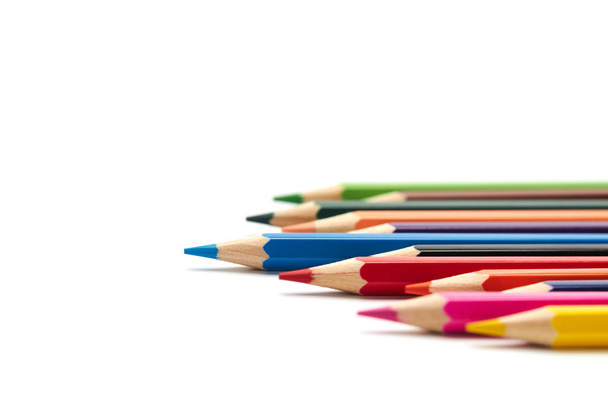 Lápiz azul se destaca de una serie de otros lápices de colores que yacen sobre un fondo blanco aislado
 - Foto, imagen