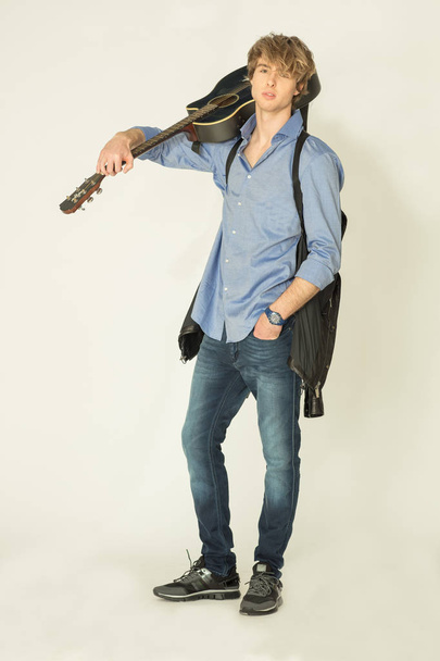 Man posing on  with guitar on light background - Photo, Image