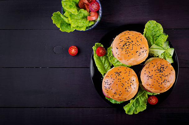 Velký sendvič s hamburgery s hovězím masem, rajčaty, sýrem a salátem. Pohled shora. Plochá ležela - Fotografie, Obrázek