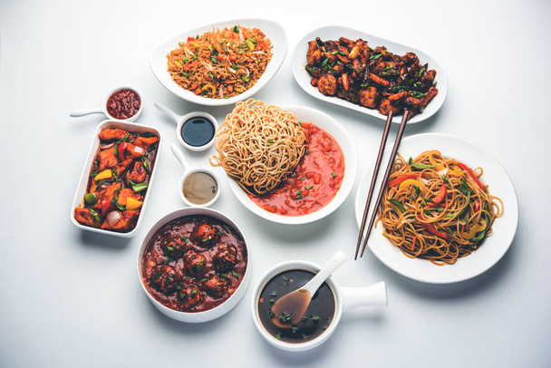 Comida chinesa Indo sortidas em grupo inclui Schezwan / Szechuan hakka macarrão, arroz frito vegetariano, manchúria veg, suey costeleta americana, paneer pimenta, crocante vegetal e sopa de legumes
 - Foto, Imagem