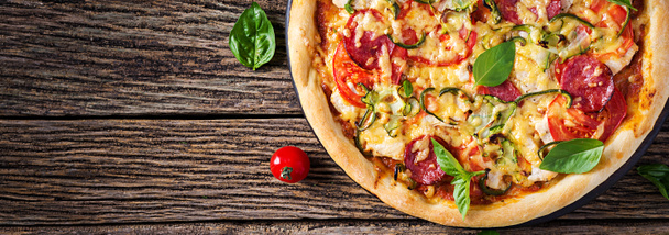 Pizza italienne au poulet, salami, courgettes, tomates et herbes
 - Photo, image