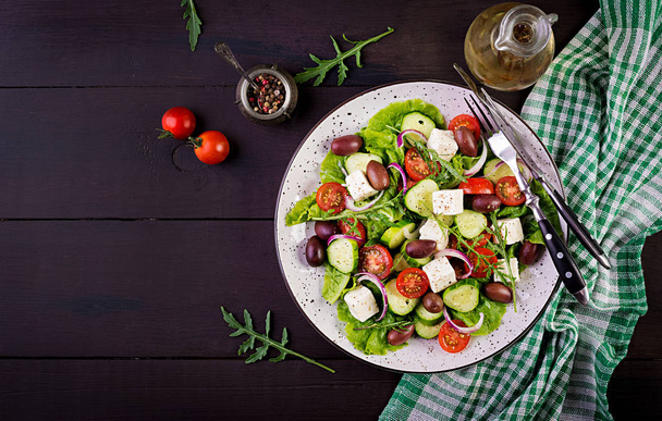 Греческий салат со свежими овощами, сыром фета и оливками каламата. Здоровое питание. Вид сверху
 - Фото, изображение