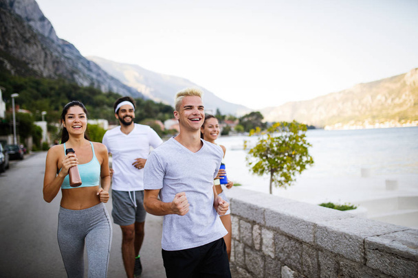 Healthy fit people running and jogging together in summer sunny nature - Foto, Bild