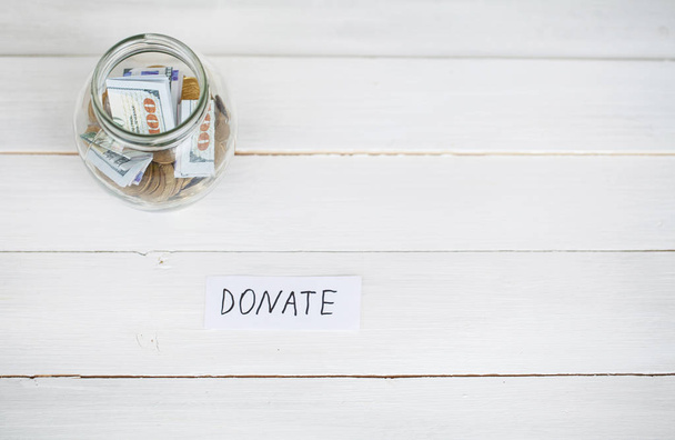 Donatie Concept. Glas met Dollars op witte achtergrond. Donaties - Foto, afbeelding