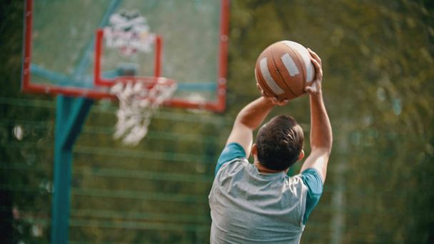 Un uomo atletico salta e sta per lanciare la palla nel canestro da basket
 - Foto, immagini