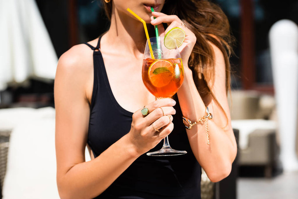 partial view of girl in swimming suit drinking cocktail on resort - Photo, Image