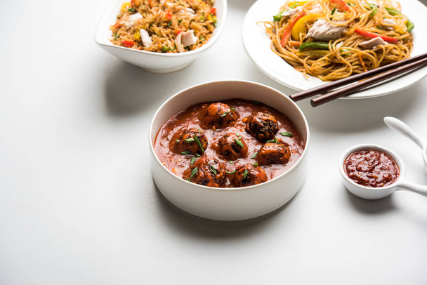 Ποικιλία Ινδοκινέζικων τροφίμων στην ομάδα περιλαμβάνει μη χορτοφαγικό ή κοτόπουλο Schezwan/Σετσουάν Χάκκα νουντλς, τηγανητό ρύζι, Μαντζουρία, αυγό American μπριζόλα, σούπα με κουτάλι και μπαστούνια ψιλοκομμάτια, επιλεκτική εστίαση - Φωτογραφία, εικόνα