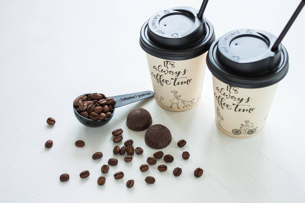 Papieren koffiekop van koffieshop met koffiebonen in de buurt van het raam. Lifestyle concept. - Foto, afbeelding