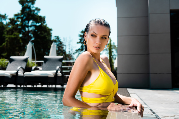 piękna seksowna Kobieta w kąpielówek stwarzających w basenie na terenie w ciągu dnia - Zdjęcie, obraz