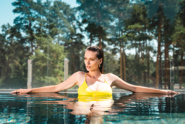 mooi sexy meisje in zwempak poseren in zwembad op Resort - Foto, afbeelding