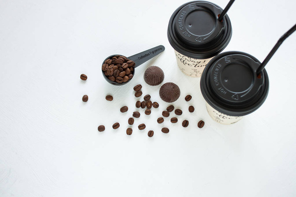 窓の近くにコーヒー豆を入れたコーヒーショップの紙のコーヒーカップ。ライフスタイルコンセプト. - 写真・画像