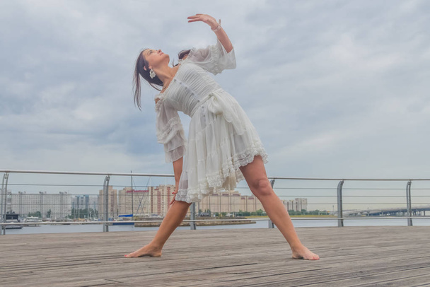 the waterfront girl in a white dress dancing - Photo, image