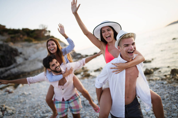 Веселые пары друзья наслаждаются выходными и веселятся на пляже - Фото, изображение