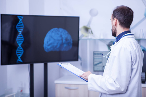 Doctor en su gabinete mirando un cerebro y tratando de poner un diagnóstico
 - Foto, Imagen