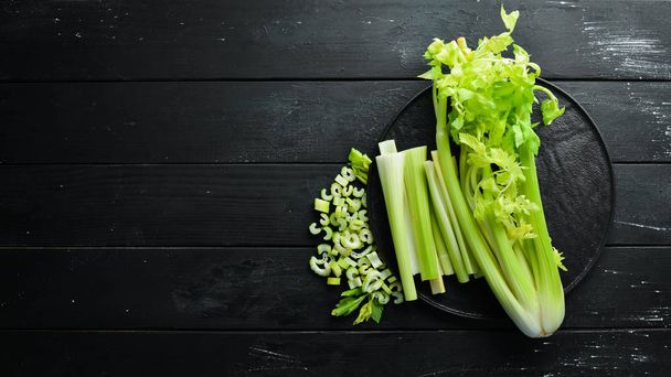 Sliced celery stalk. On a black background. Healthy food. Top view. Free space for your text. - Valokuva, kuva