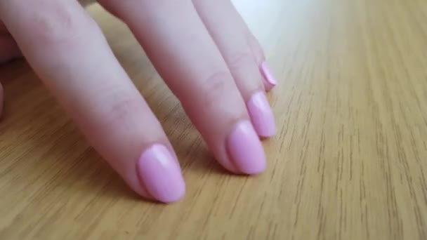 Mano femenina con piel blanca y uñas cortas rosadas knokcs y rascarse una mesa de madera
   - Imágenes, Vídeo