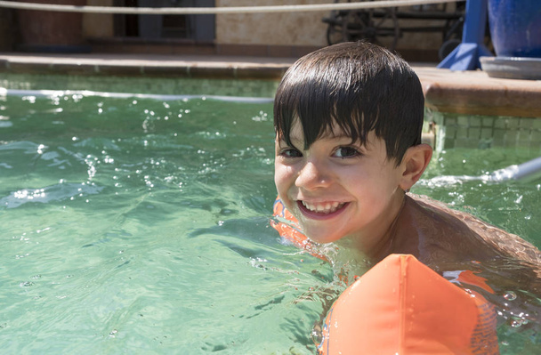 Garçon portant des flotteurs bras dans une piscine
 - Photo, image