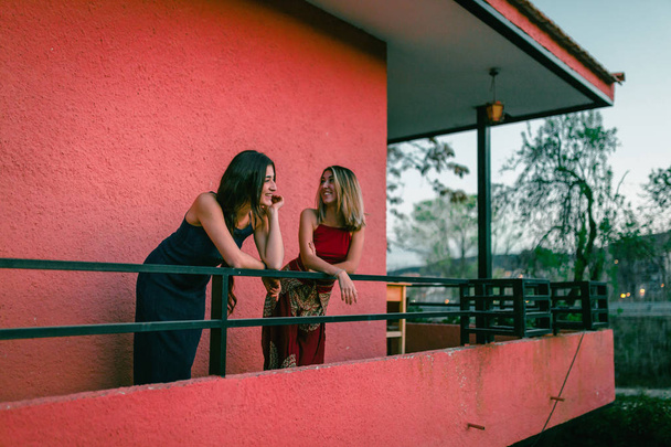 Dwie młode kobiety oglądać zachód słońca z ich balkonu. - Zdjęcie, obraz