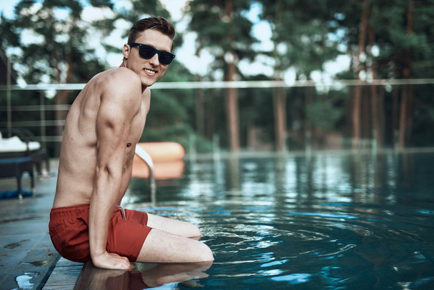 Low angle of young attractive guy enjoying vacation in summer - Fotografie, Obrázek