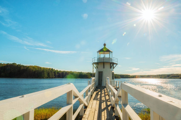 Lighthouse on the bay. Doubling Point Light is a lighthouse on the Kennebec River in Arrovich, Maine. USA. Maine. Beautiful green shores of the reservoir and the village bridge to the lighthouse. - Фото, зображення