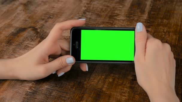 Kobieta trzyma czarny smartfon z pustym zielonym ekranem-koncepcja makiety - Materiał filmowy, wideo