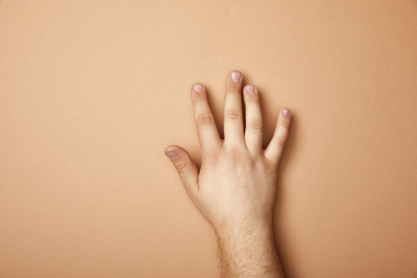 partial view of male hand on beige background with copy space - Фото, зображення