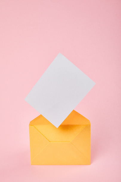 yellow envelope with blank white card on pink background - Photo, Image