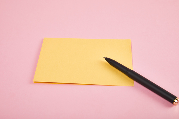 yellow envelope with pen on pink background - Φωτογραφία, εικόνα