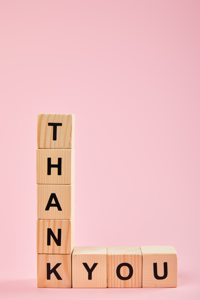 wooden cubes with thank you lettering on pink background with copy space - Foto, imagen