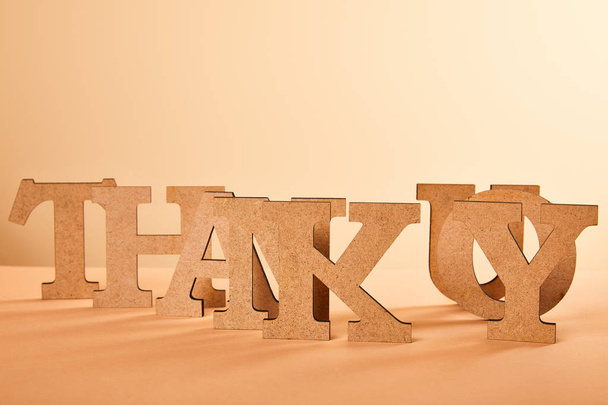 papel cortado gracias letras en la mesa aislado en beige
 - Foto, Imagen