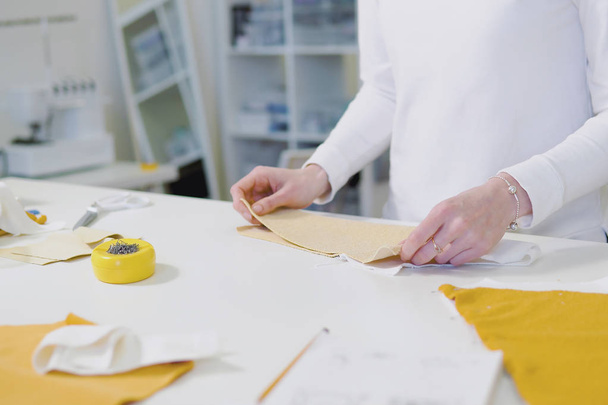 Дизайнер моди або пошивна ріжуча тканина під час роботи з ескізом малюнка, матеріалом на робочому столі. Концепція швейного бізнесу. вид зверху
 - Фото, зображення