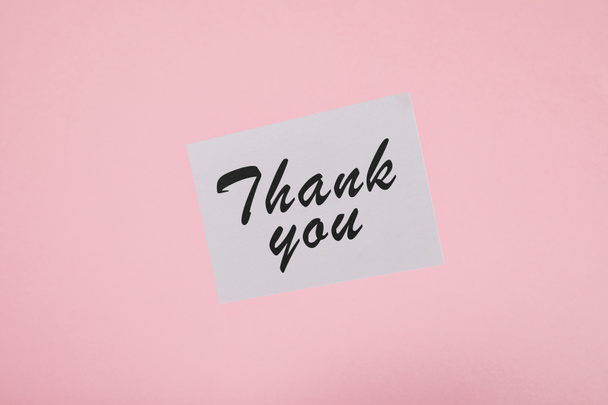 top view of white card with thank you inscription on pink background - Photo, Image