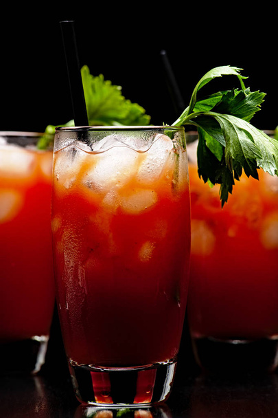 Cropped frame of Bloody Mary with ice cubes with celery isolated on black - Foto, Imagen