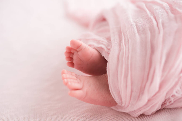 Closeup view of newborn baby feet wrapped in pink - Φωτογραφία, εικόνα